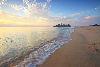 Serene Beach Sunset with Gentle Waves and Distant Island