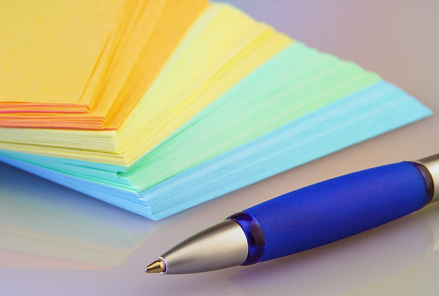 Colorful Sticky Notes and Blue Pen on White Surface