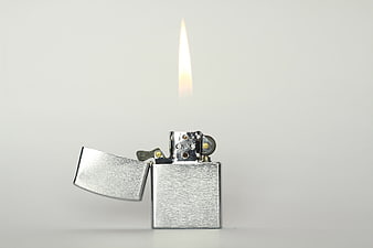 Silver lighter with flame on white background