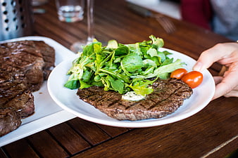 Grilled steak with fresh salad on white plate