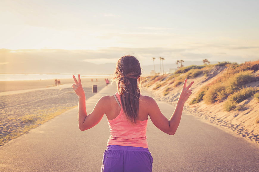Woman Jogging On Beach Path At Sunset