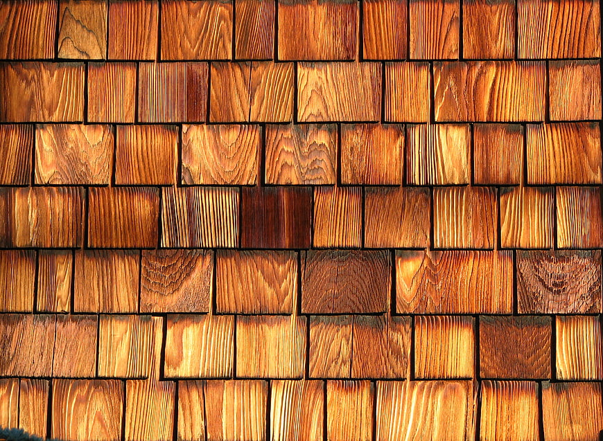 Close-up texture of warm brown wooden shingles on a wall