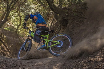 Mountain Biker Cornering on Dirt Trail in Forest