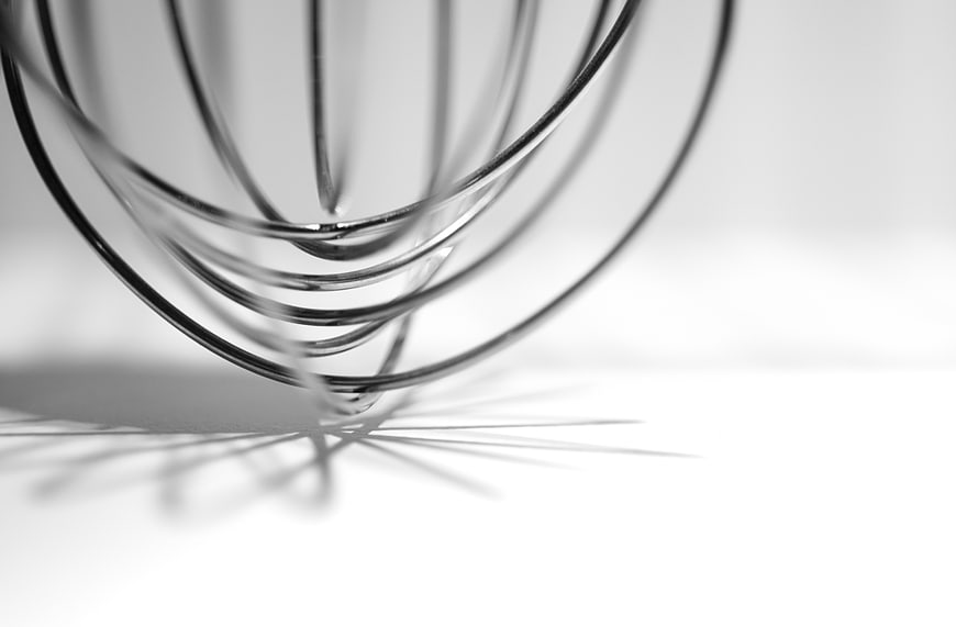 Close-up of metal whisk on white background