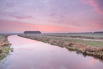 Serene Canal Landscape with Pink Sunset Reflections