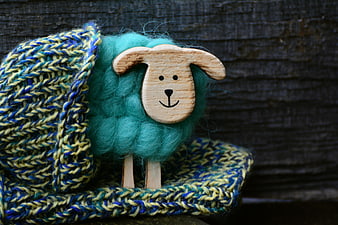 Handmade Wool Sheep Toy Wearing Knitted Hat on Dark Wood Background