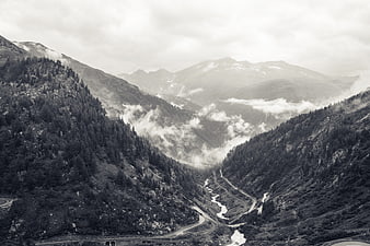 Black and white mountain valley with winding road and river