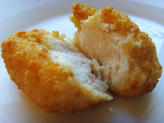 Close-up of golden fried chicken nugget cut in half