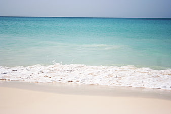 Turquoise Ocean Waves Washing On White Sandy Beach Shoreline