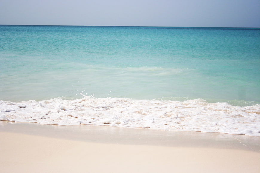 Turquoise Ocean Waves Washing On White Sandy Beach Shoreline