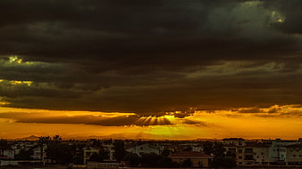 Dramatic golden sunset with sunbeams over coastal town