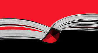 Open Book with Red Gemstone on Red and Black Background
