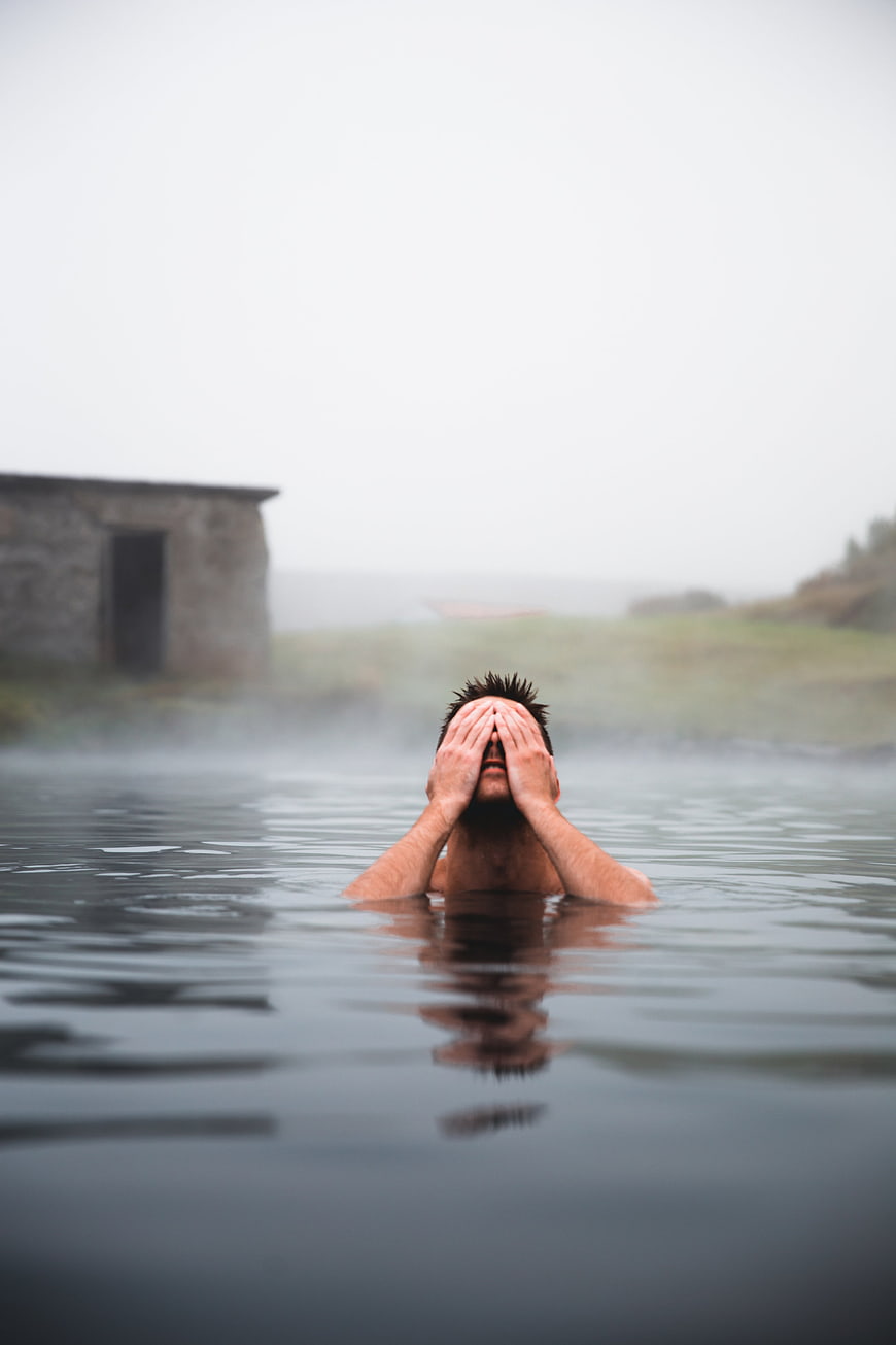 Man relaxing in misty outdoor hot spring