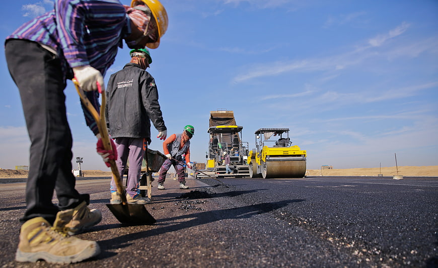 Road Construction Workers Laying Asphalt With Heavy Machinery