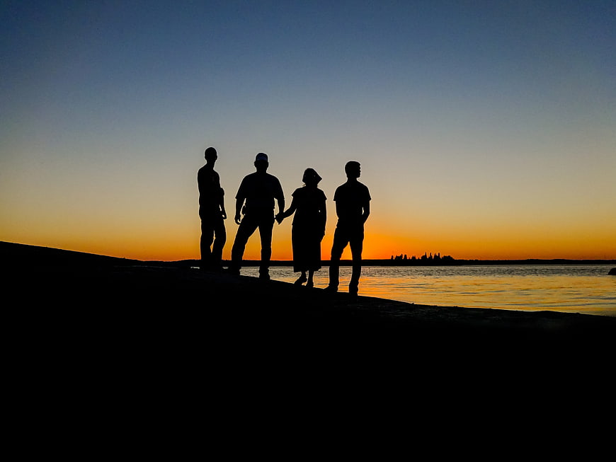 Silhouette of Four Friends Standing on Beach at Sunset