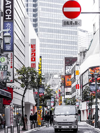 Busy Japanese City Street with White Truck and Neon Signs