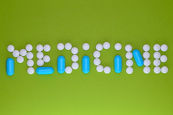 Medicine word spelled with white and blue pills on green background
