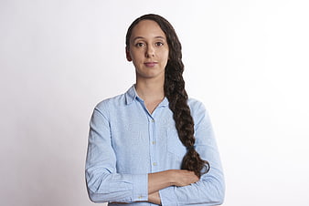 Portrait of confident young woman with long braid in blue shirt