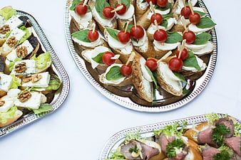 Assorted appetizers on silver platters with caprese and blue cheese