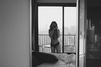 Woman taking mirror selfie in black and white