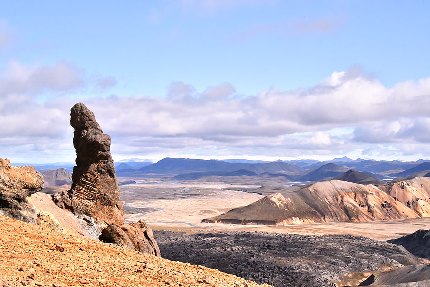 Vast Icelandic landscape with rock formation and distant mountains