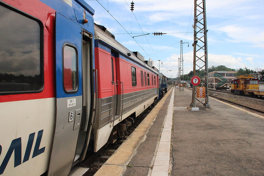 Korean passenger train at station platform with overhead wires