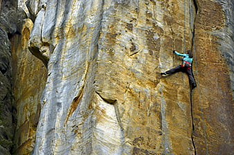 Woman rock climbing on steep cliff face