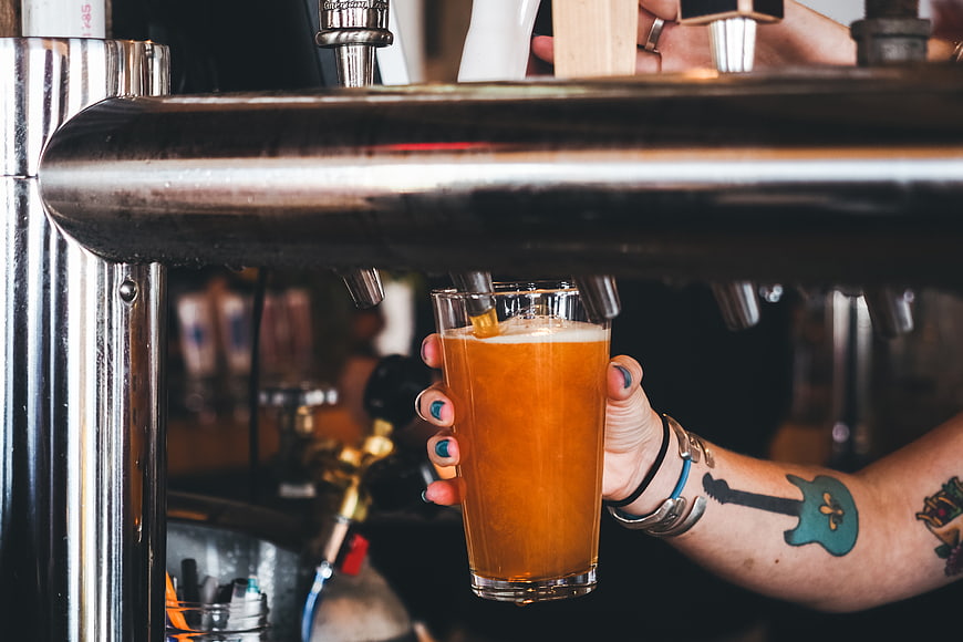 Tattooed Hand Pouring Craft Beer from Tap