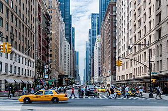 Busy New York City street with yellow taxi and pedestrians