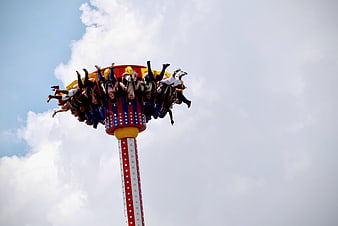 People on a spinning drop tower amusement park ride