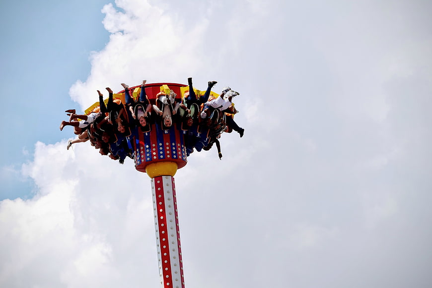 People on a spinning drop tower amusement park ride