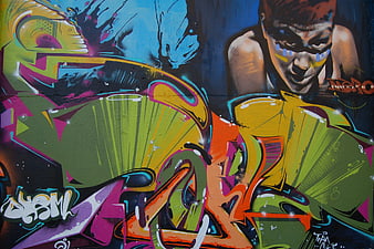 Vibrant graffiti mural with stylized character and wildstyle lettering
