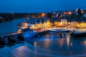Aerial view of Vannes harbor at twilight with illuminated buildings and flowing water