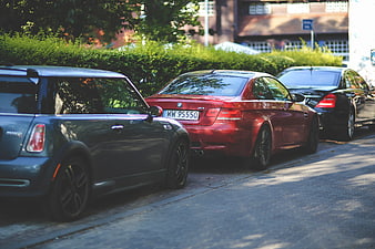 Red BMW M3 and Mini Cooper parked on cobblestone street