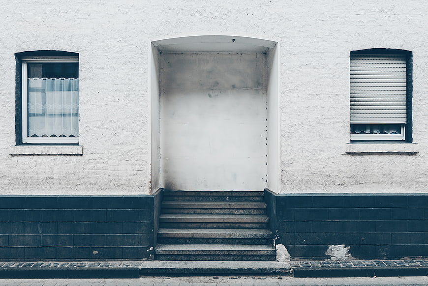Minimalist white building facade with stairs and windows