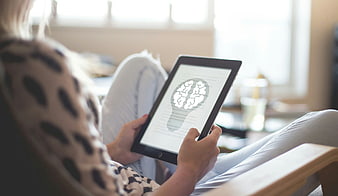 Woman holding tablet with brain icon on screen
