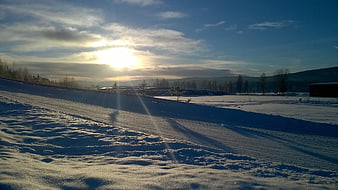 Sunset over a snowy winter landscape with long shadows
