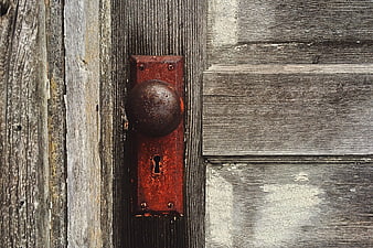 Rusty vintage door knob on weathered wooden planks