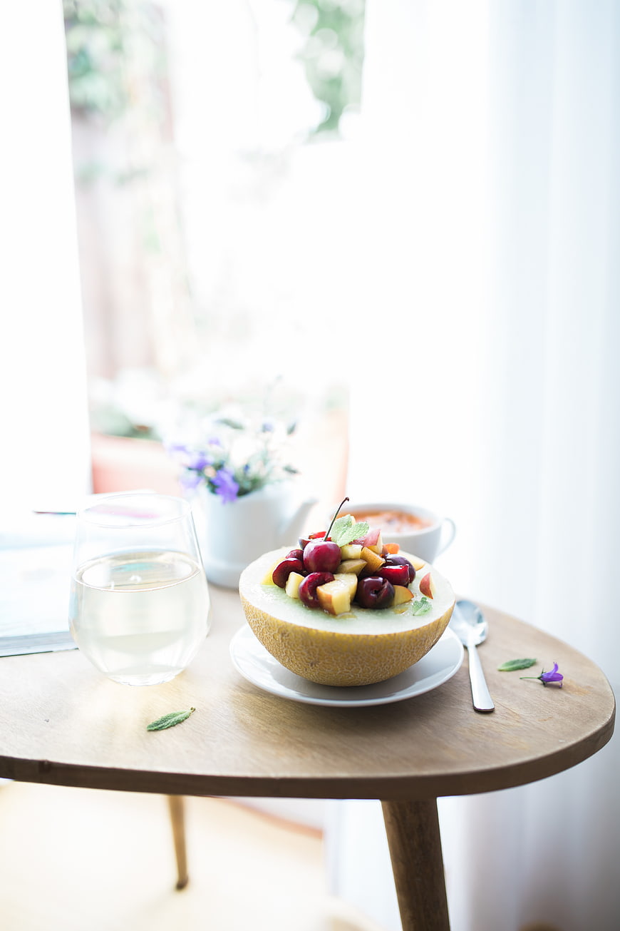 Fresh fruit salad in melon bowl on wooden table