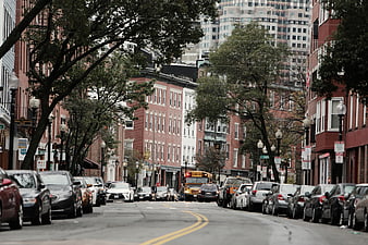 Urban street scene with parked cars and school bus