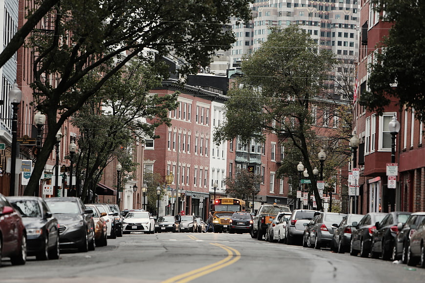 Urban street scene with parked cars and school bus