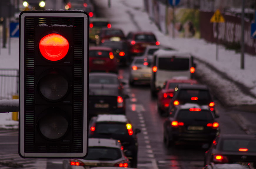 Red Traffic Light with Snowy Winter Traffic Jam Background
