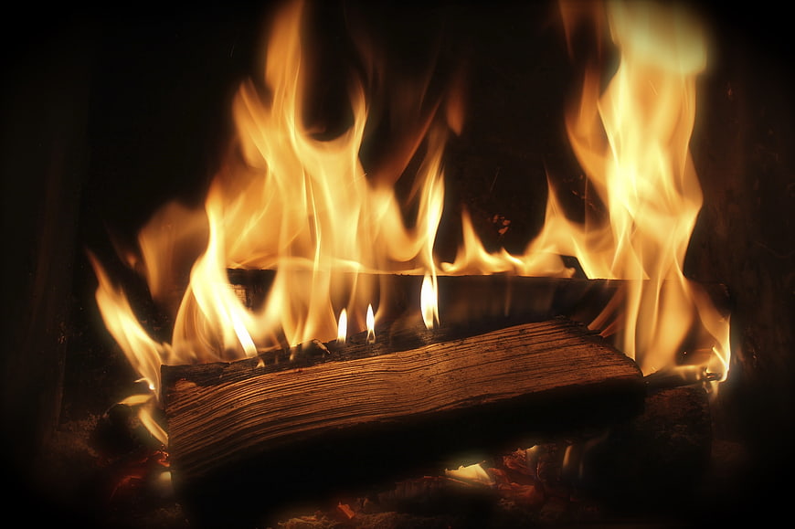 Close-up of burning logs in a fireplace with bright flames