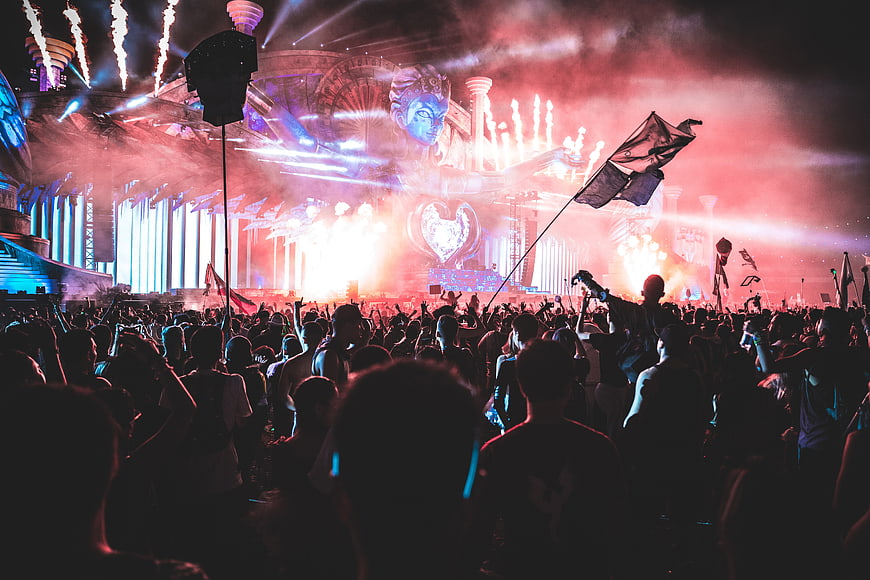 Vibrant Music Festival Crowd With Pyrotechnics And Stage Lights