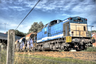 Blue Freight Train on Tracks with Wooden Fence Post