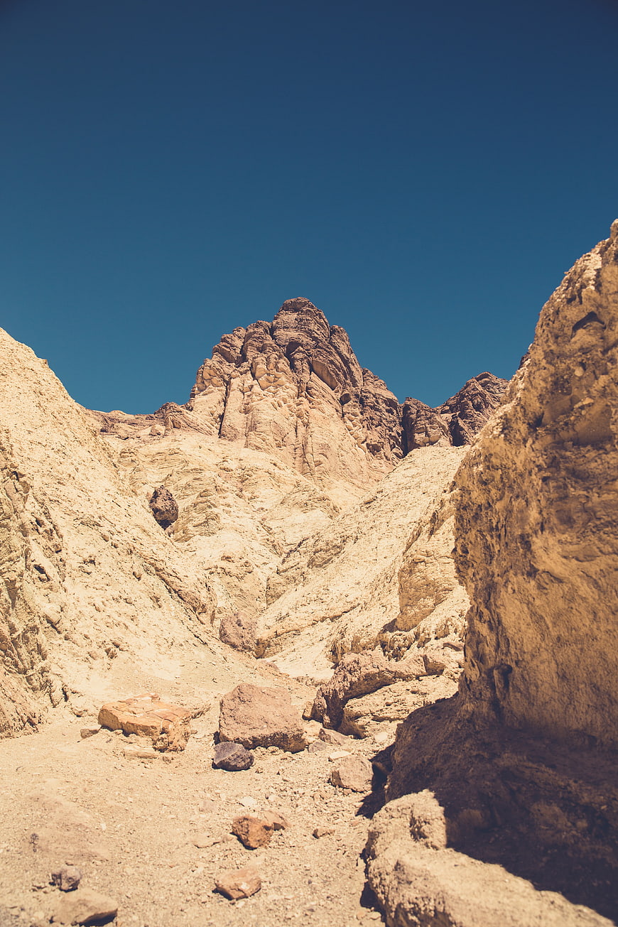 Rugged desert canyon landscape with rocky peaks and blue sky