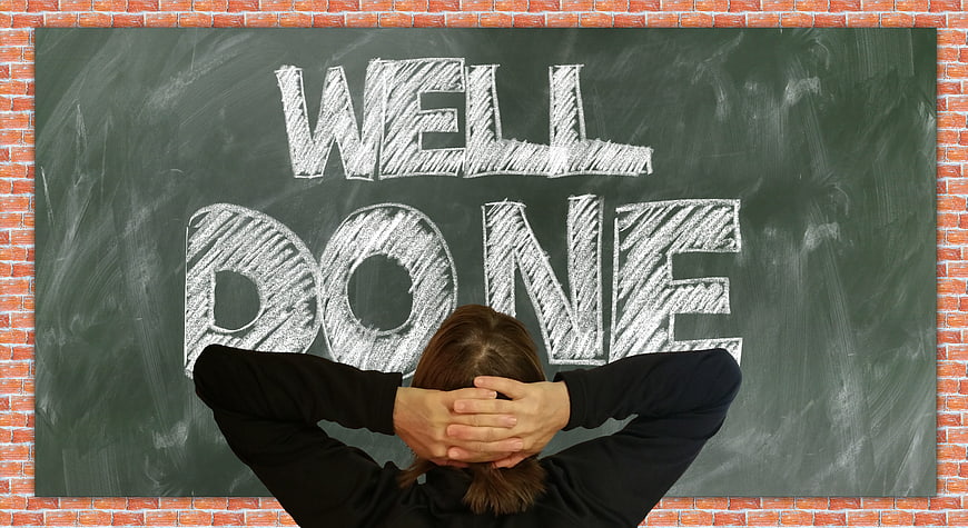 Person relaxing with hands behind head in front of chalkboard