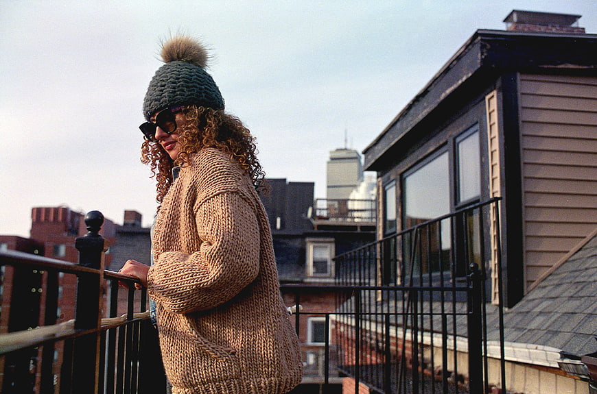 Woman in Chunky Knit Sweater and Beanie on Urban Rooftop
