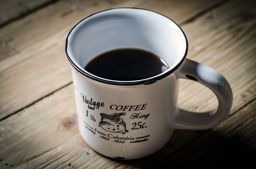Vintage White Enamel Coffee Mug on Wooden Table