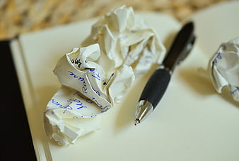 Crumpled paper balls and pen on notebook page